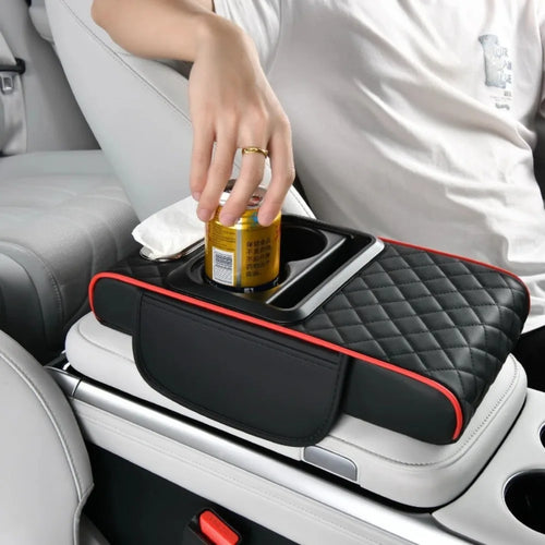Car armrest organizer with cup holder and storage space, used by a person.